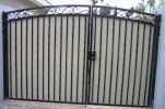 Arched decorative RV gate with hand-hammered Italian scrolls and plate steel for privacy