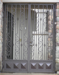 Decorative double entry gate with solid twisted pickets, scrolls and diamond kickplate