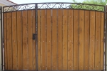 a decorative arched driveway gate with medium stained clear ceda